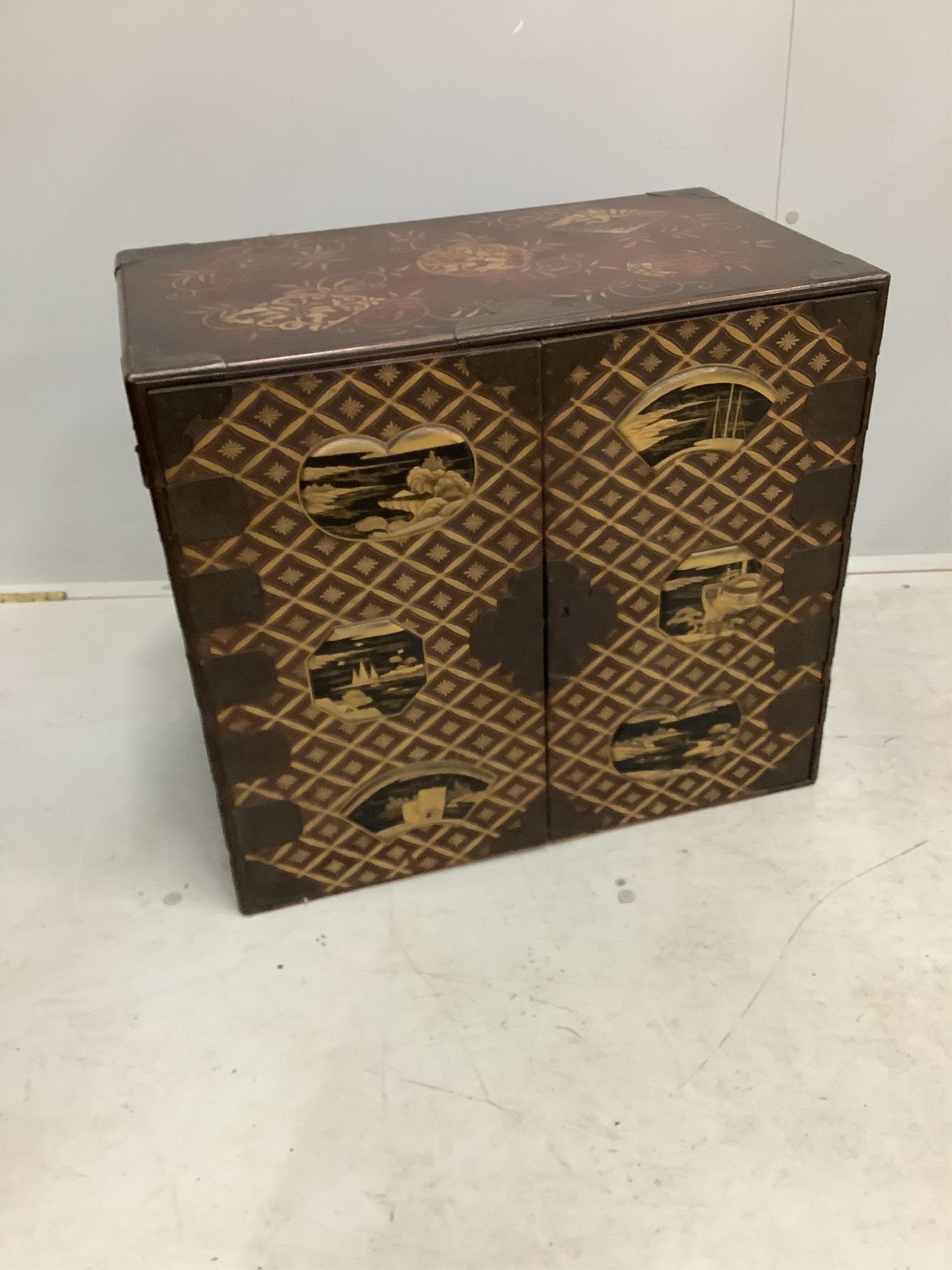 A 19th century Japanese gilt decorated lacquer table cabinet with two doors enclosing three drawers, width 61cm, depth 36cm, height 54cm. Condition - fair to good